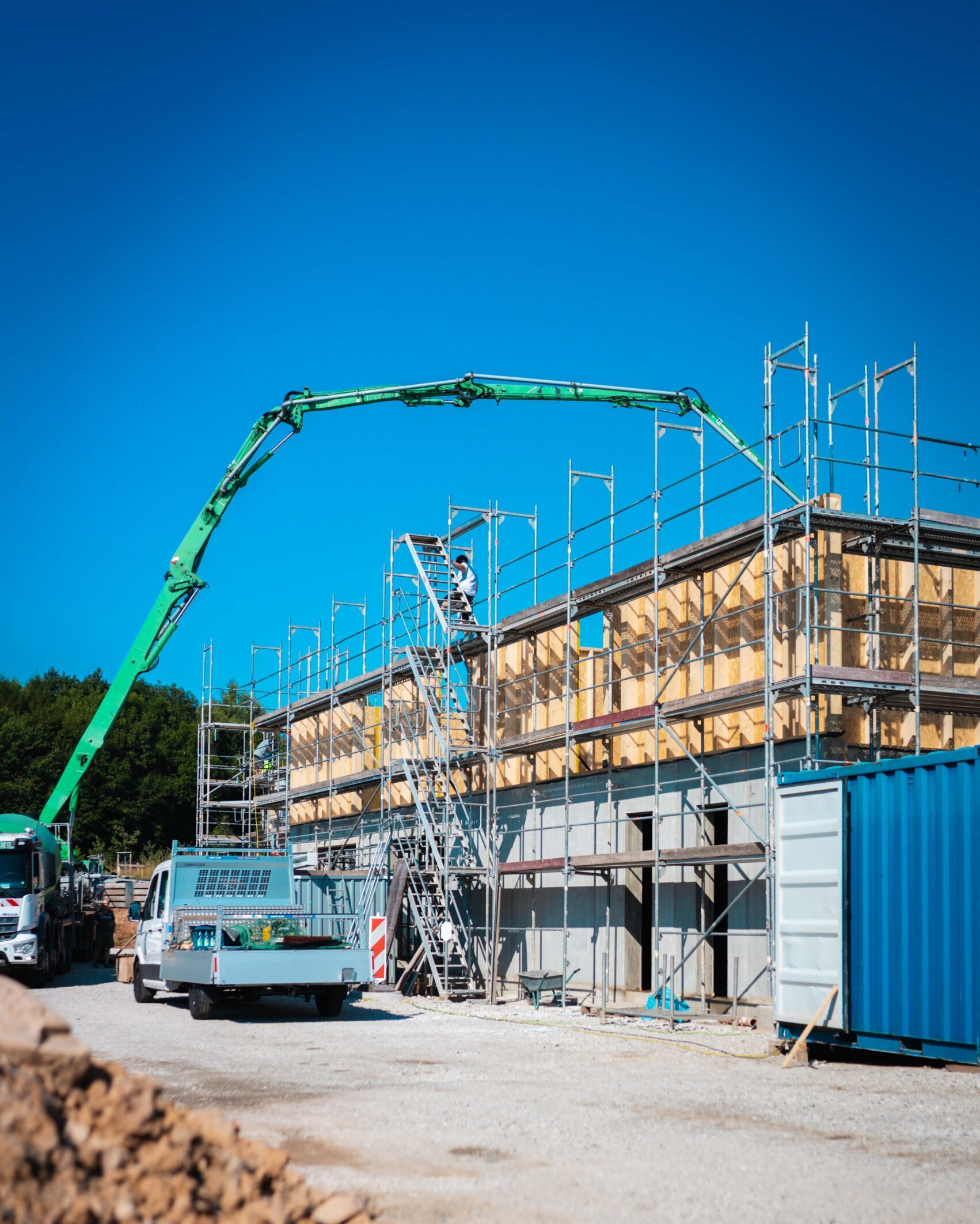 Betonpumpe mit LKW im Einsatz bei Holz-Mischbauweise-Neubau mit Gerüst