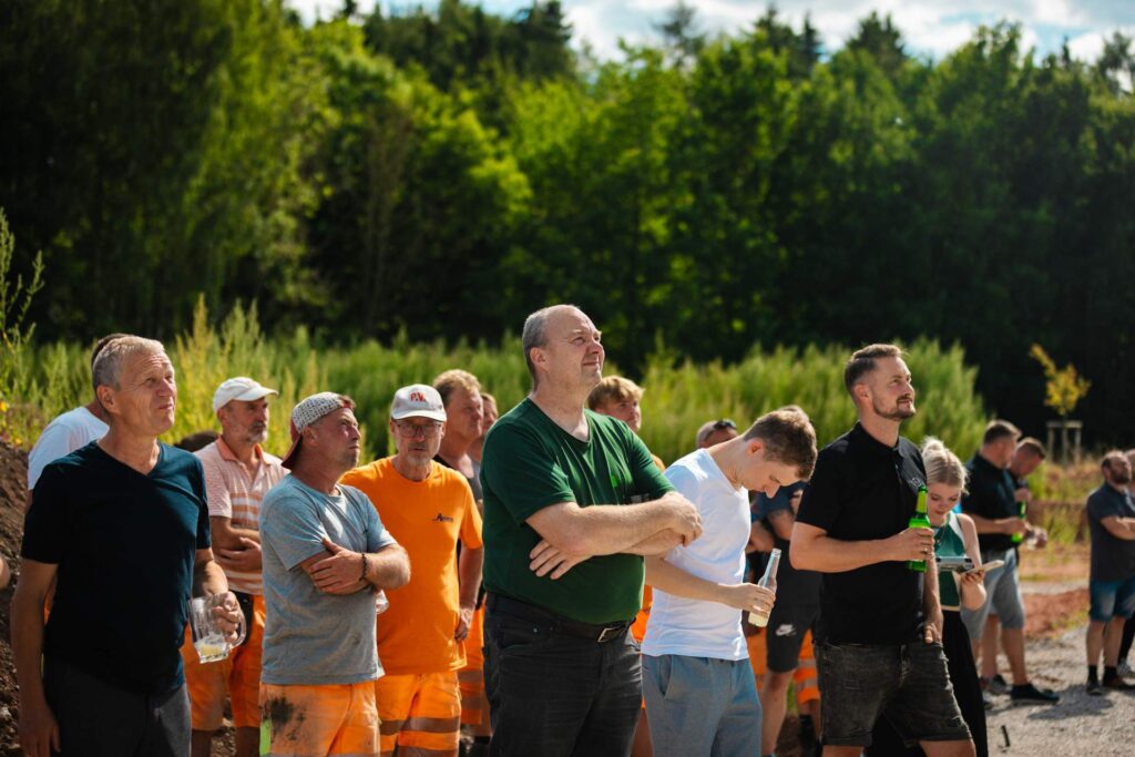 Gäste, Handwerker und Beteiligte schauen aufmerksam nach oben zum Richtspruch beim Richtfest in St. Egidien.